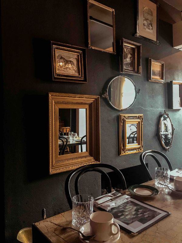 Como Decorar Ambientes Pequenos - 11 Dicas e Layout 3 como decorar ambientes pequenos, imagem mostra uma sala de jantar com parede escura e varios espelhos em formatos diferentes