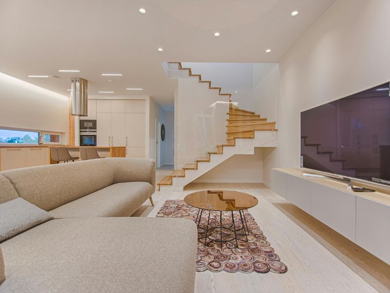 Como Decorar Sala de TV em 6 Passos 1 como decorar sala de tv, imagem mostra uma sala de tv clara, com sofa bege, rack branco, mesa de centro bronze e tapete colorido