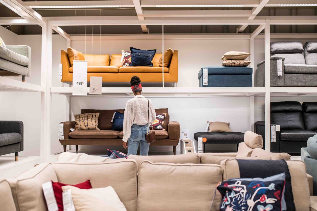 Dicas De Como Decorar Sem Gastar Muito 1 decorar sem gastar muito, imagem mostra mulher pesquisando sofas em loja de decoracao